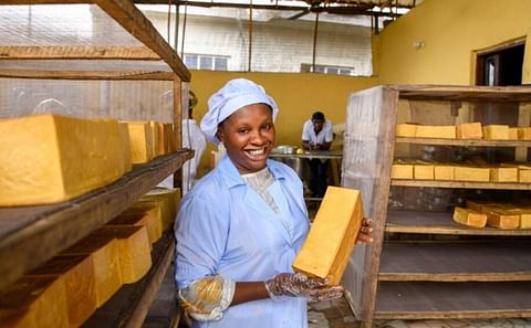 A baker holds a loaf of orange-fleshed sweet potato bread in her bakery in Nnewi (Courtesy: Esomchi Foundation)