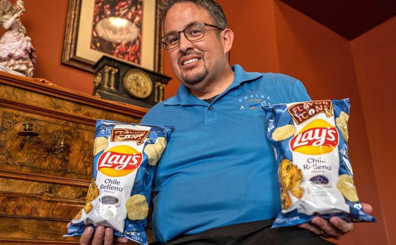 Frank Barela Jr., general manager of Cocina Azul in Albuquerque, holds two bags of chile relleno-flavored chips. The flavor, inspired by the restaurant, will hit store shelves July 27. Frank Barela Jr., general manager of Cocina Azul in Albuquerque, holds two bags of chile relleno-flavored chips. The flavor, inspired by the restaurant, will hit store shelves July 27.