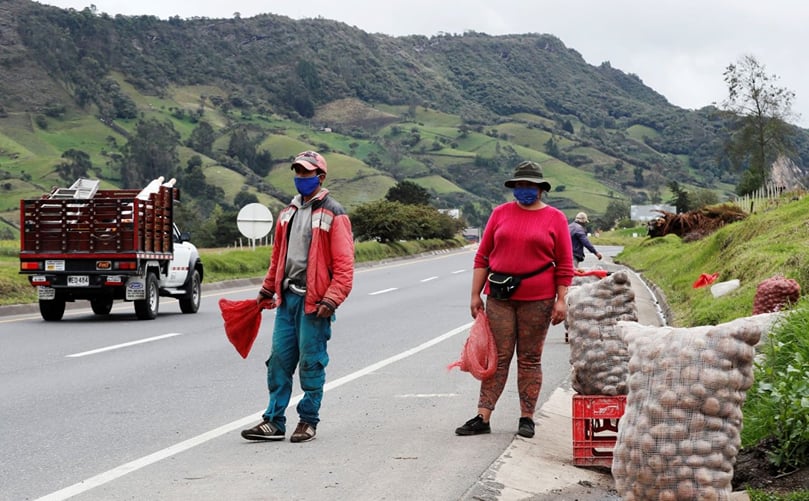 Agricultores colombianos vendiendo sus sacos de papas a los que transitan por la autopista. Agricultores colombianos vendiendo sus sacos de papas a los que transitan por la autopista.