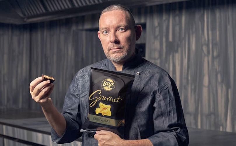 Albert Adriá, con una bolsa de Lays Gournet y un trozo de su turrón.