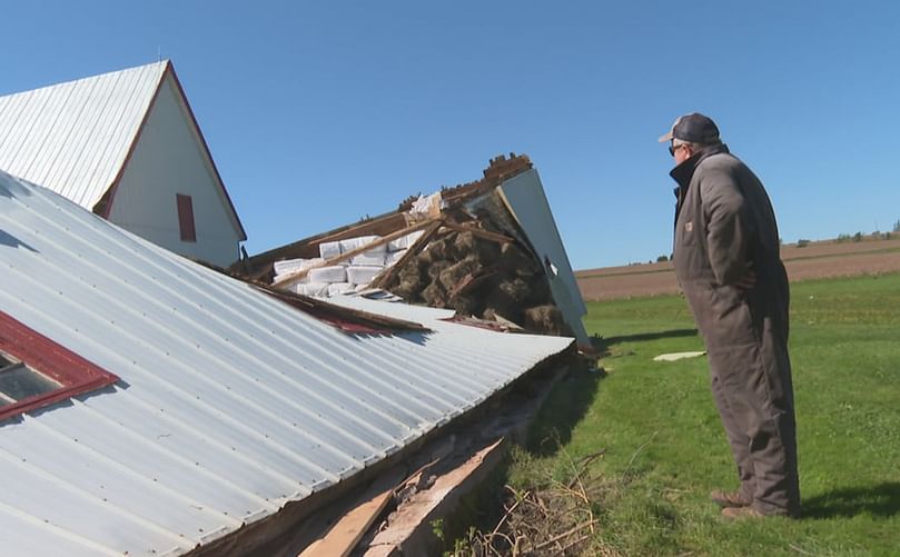 Alex Docherty looking at a destroyed building at his farm