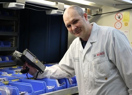 Calculated in a split second: Attila Szabó holds a scanner to the shelf and finds out how many spare parts are still on hand.