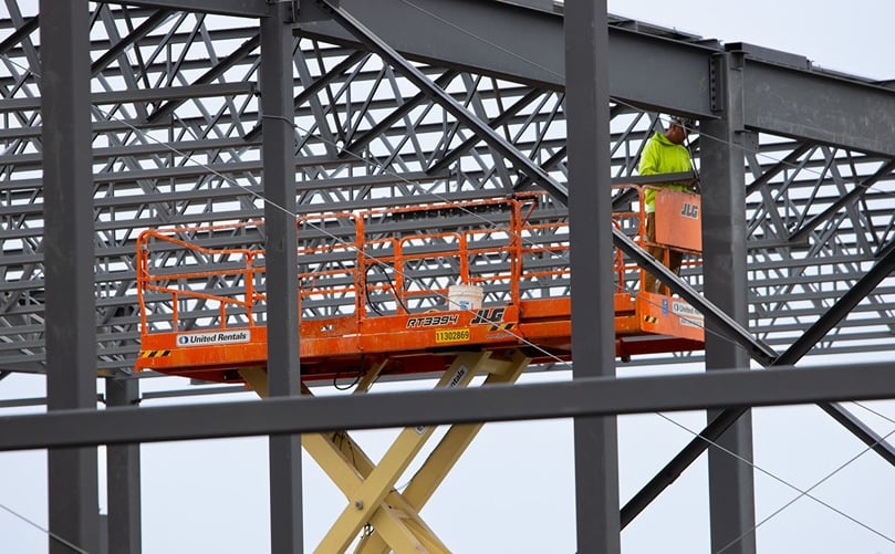 A construction worker stands atop a scissor lift at the Taste of Maine Potato Chip Co. plant construction site. (Courtesy: The Country) A construction worker stands atop a scissor lift at the Taste of Maine Potato Chip Co. plant construction site. (Courtesy: The Country)