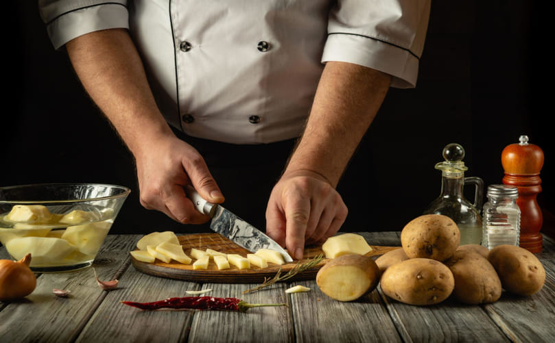 Home Kitchen Potato Preparation: Cutting Fresh Potatoes Before Cooking