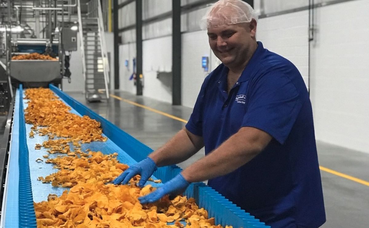 Jason Huey, Bethel Operations Manager at Dieffenbach's Potato Chips, is inspecting the organic sweet potato chips being produced in the new facility.