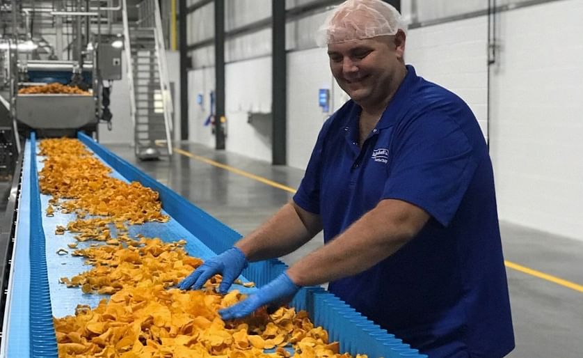 Jason Huey, Bethel Operations Manager at Dieffenbach's Potato Chips, is inspecting the organic sweet potato chips being produced in the new facility.