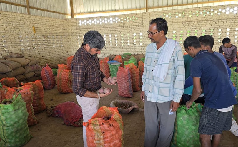 Harvinder Singh discussing potato quality and seed selection with local farmers inside the storage facility.. Harvinder Singh discussing potato quality and seed selection with local farmers inside the storage facility.