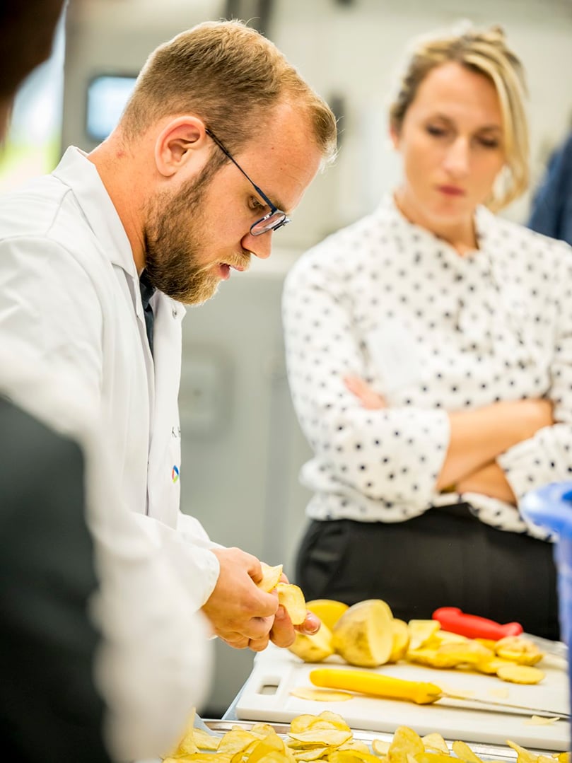 Elea expert prepares sliced potatoes to demonstrate the impact of PEF on texture and cutting performance.