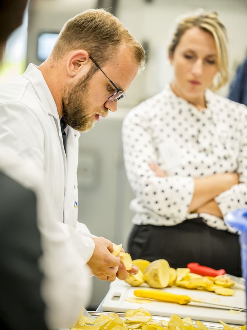 Elea expert prepares sliced potatoes to demonstrate the impact of PEF on texture and cutting performance.