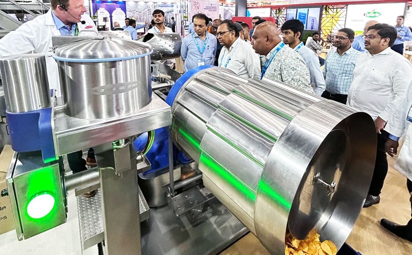 Heat and Control's FastBack® Symphony On-Machine Seasoning System on display, demonstrating advanced seasoning technology for improved accuracy and production efficiency. Heat and Control's FastBack® Symphony On-Machine Seasoning System on display, demonstrating advanced seasoning technology for improved accuracy and production efficiency.