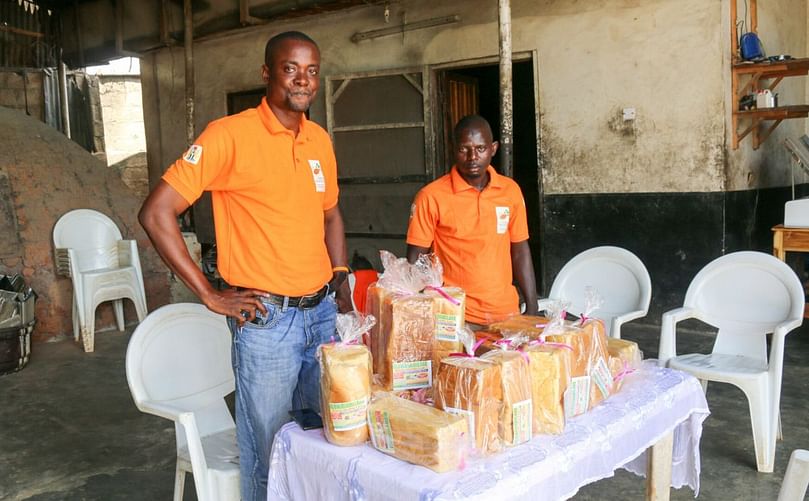 Fatai Ganiyu (left) displaying OFSP bread loaves made BY his bakery (Courtesy: CIP)