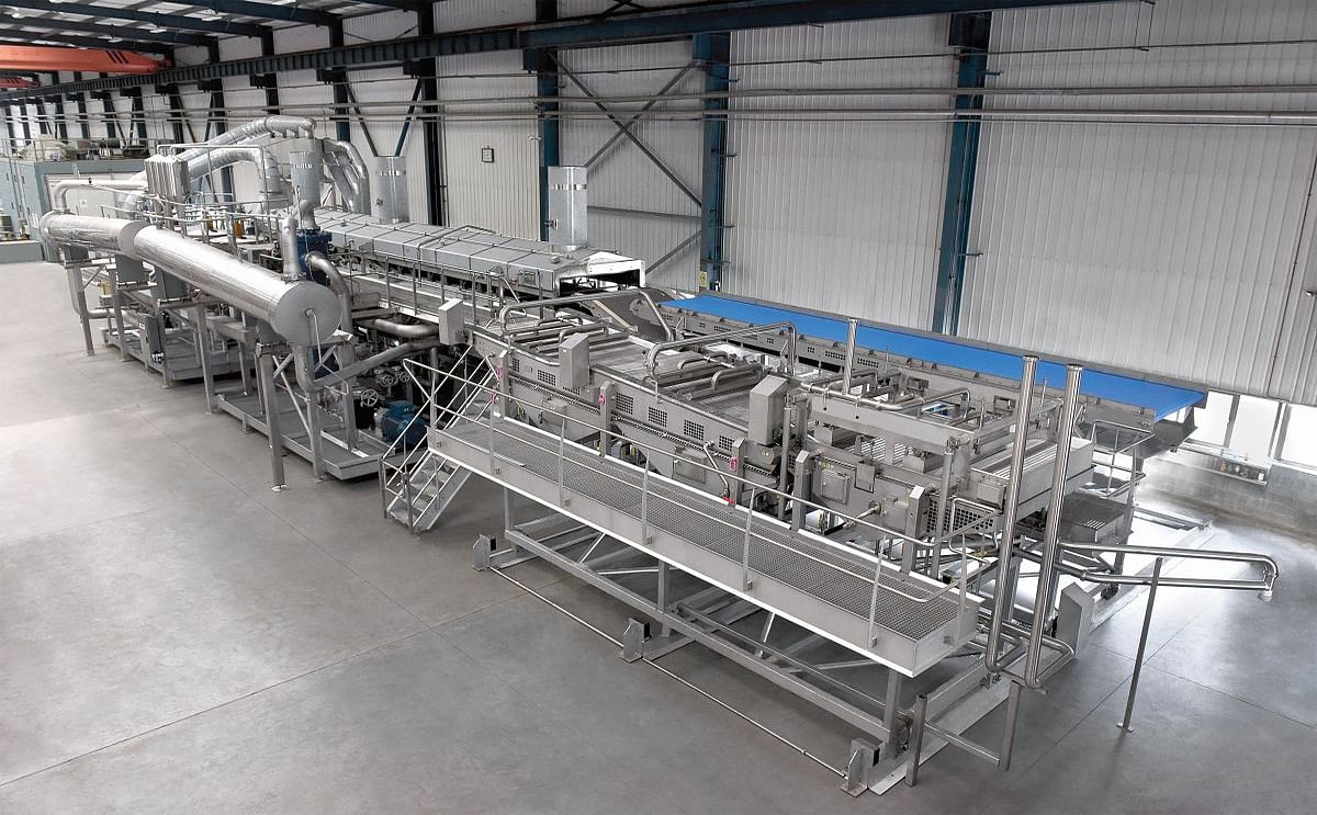 This integrated system built by Heat and Control has a capacity of 17,000 kg/hr (37,400 lbs/hr) and includes a batter applicator design that allows for frying of coated and uncoated fries by simply moving the coating equipment into and out of position. 