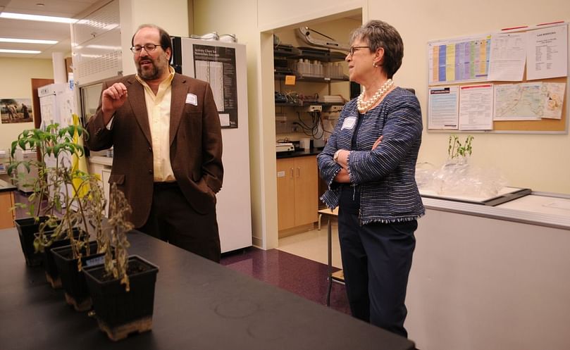 Howard Judelson (left) explains his research to USDA Under Secretary for Research, Education and Economics Cathie Woteki (Courtesy: UCR Strategic Communications). Howard Judelson and USDA Under Secretary for Research, Education and Economics Cathie Woteki