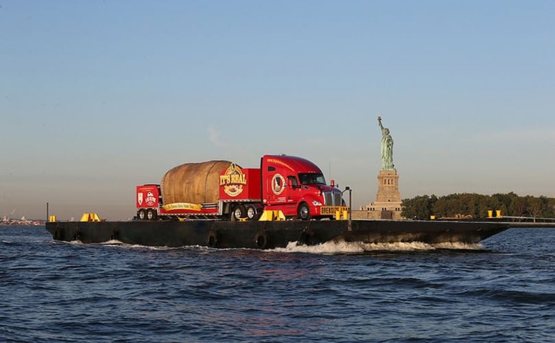 The Big Idaho Potato Truck floats past the Statue of Liberty