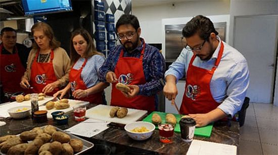 Students take a stab at prepping Idaho potatoes during a Guatemala City cooking class.
