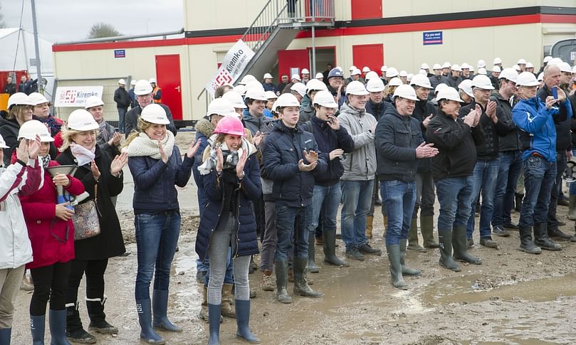 Employees & guests watch the striking of the first pile after they collectively signed it Employees & guests watch the striking of the first pile after they collectively signed it