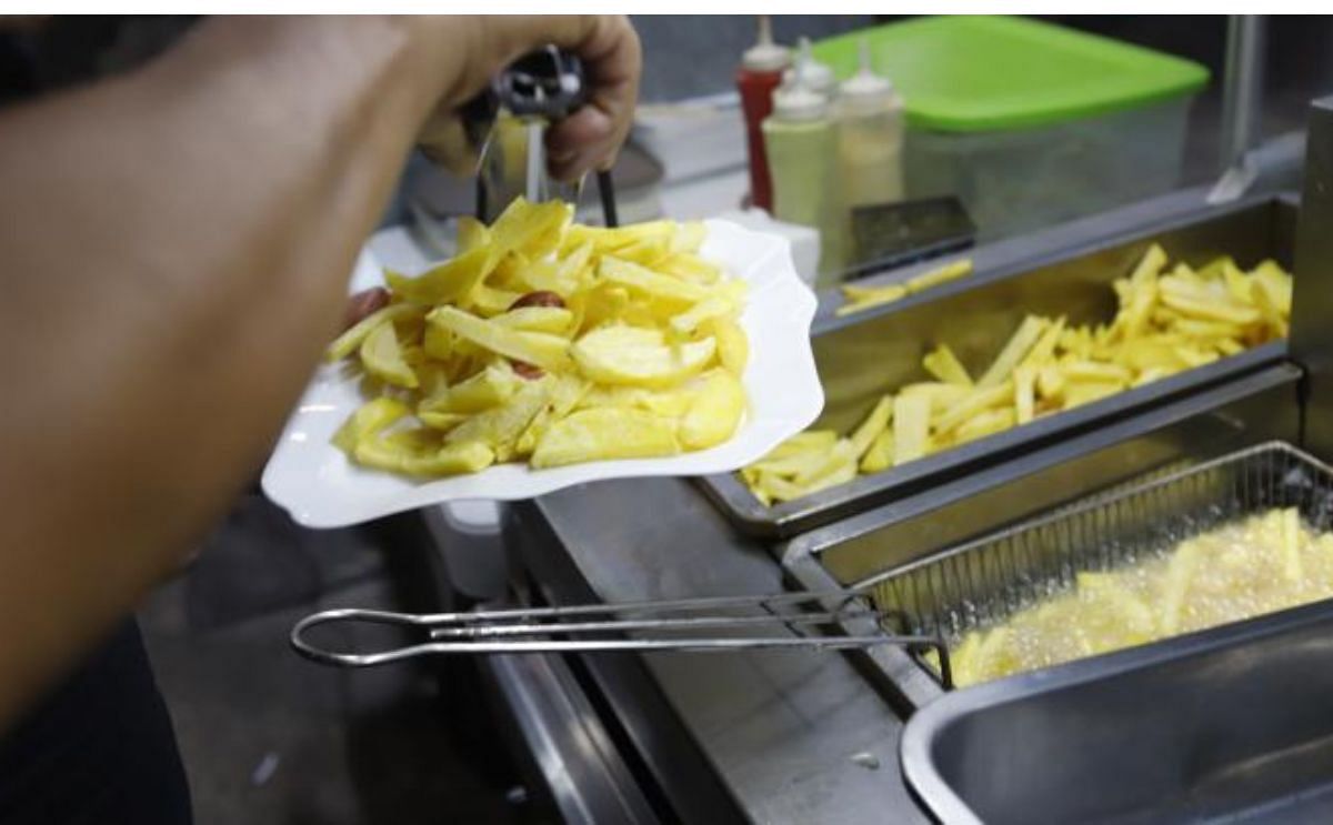Local. El ayudante en uno de los locales, especializado en la salchipapa y papipollo, fríe la papa. (Cortesía: Amelia Andrade) Local. El ayudante en uno de los locales, especializado en la salchipapa y papipollo, fríe la papa. (Cortesía: Amelia Andrade)