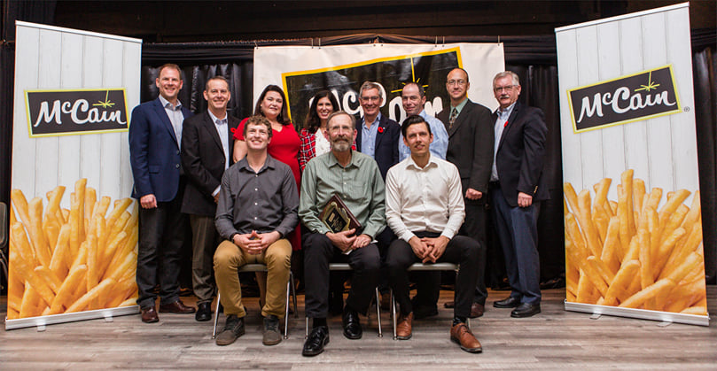 Top Innovator Variety Award – Beaver Creek Farms Ltd. with McCain management
Front, l-r: Andrew Doerksen, Stan Wiebe, Darryl Wiebe
Back, l-r: Bob Hyra, Director Agriculture NA Mid-West, Jim Waugh, Sr. Director Manufacturing, Christine Wentworth, VP Agriculture NA, Danielle Barran, President, McCain Foods Canada, Allison McCain, Chairman, McCain Foods Limited, Bart Witherspoon, Field Department Manager, Dean Melnic, Portage Plant Manager, Dale McCarthy, VP Integrated Supply Chain NA.
Top Innovator Variety Award – Beaver Creek Farms Ltd. with McCain management
Front, l-r: Andrew Doerksen, Stan Wiebe, Darryl Wiebe
Back, l-r: Bob Hyra, Director Agriculture NA Mid-West, Jim Waugh, Sr. Director Manufacturing, Christine Wentworth, VP Agriculture NA, Danielle Barran, President, McCain Foods Canada, Allison McCain, Chairman, McCain Foods Limited, Bart Witherspoon, Field Department Manager, Dean Melnic, Portage Plant Manager, Dale McCarthy, VP Integrated Supply Chain NA.