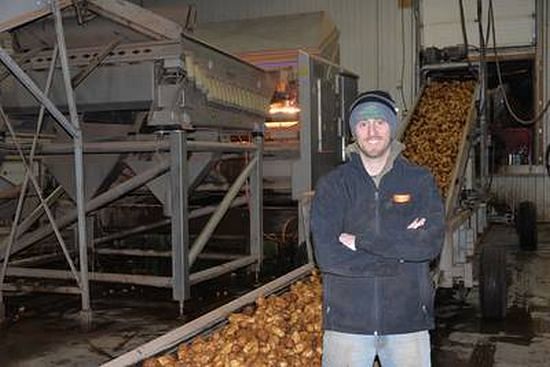 Chris Hunt, P.E.I. Potato Solutions plant manager, stands in front of the $1.1 million chemical imagine machine that detects foreign objects, such as golf balls and rocks, as they pass through.