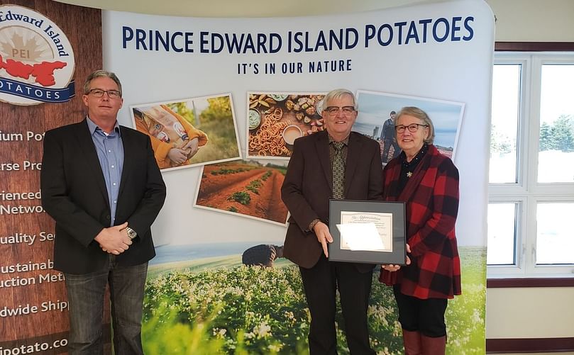 PEI Potato Board Director Jason Hayden (left) presents Potato Industry Recognition Award to Charles and Wilhelmina Murphy (right).