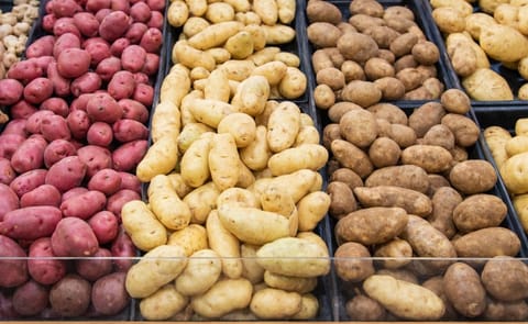 Different potato varieties on display in a grocery store. Different potato varieties on display in a grocery store.