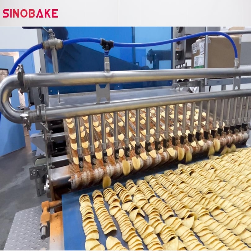 Precise seasoning application on SINOBAKE’s potato chip line, where advanced dispensing technology ensures uniform coating, enhanced flavor, and consistent quality in every batch.