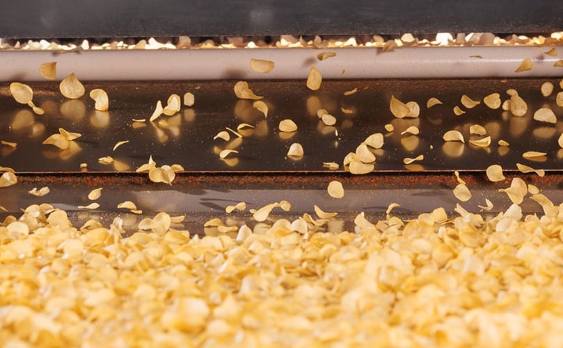 Potato chips in motion on a processing line—minimizing surface moisture at this stage helps reduce frying energy consumption and improve efficiency. Potato chips in motion on a processing line—minimizing surface moisture at this stage helps reduce frying energy consumption and improve efficiency.