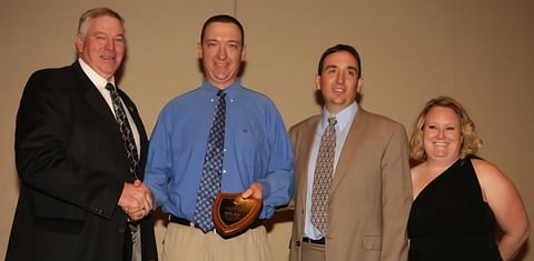 NPC 2014 President Randy Hardy hands the award to Brendon Rockey and Sheldon Rockey with wife Nicole.