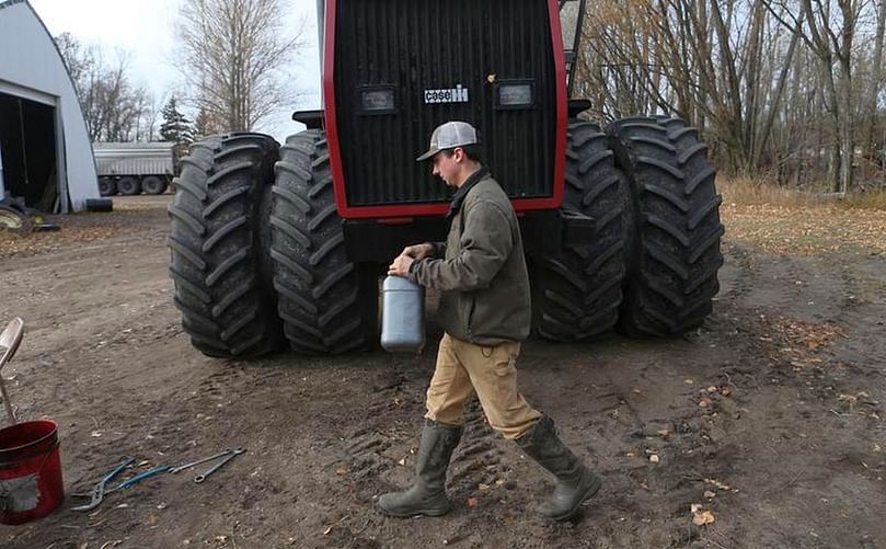 Karlstad, Minn., seed potato farmer Sander Dagen changes oil on a tractor before putting it away for winter. (Courtesy: by Eric Hylden | Grand Forks Herald)