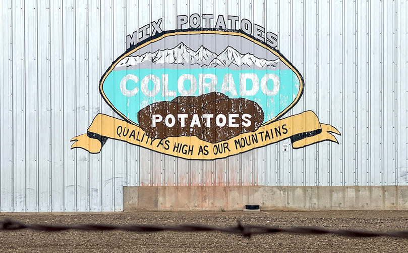 An advertisement for Colorado potatoes painted on the side of a shed in Center, Colo. on June 30, 2022. (Courtesy: Michael Elizabeth Sakas/CPR News) An advertisement for Colorado potatoes painted on the side of a shed in Center, Colo. on June 30, 2022.