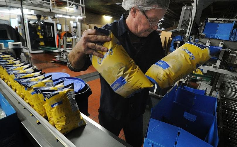 Tim White, a 26 year employee of Mikesell's packs bags of chips into boxes