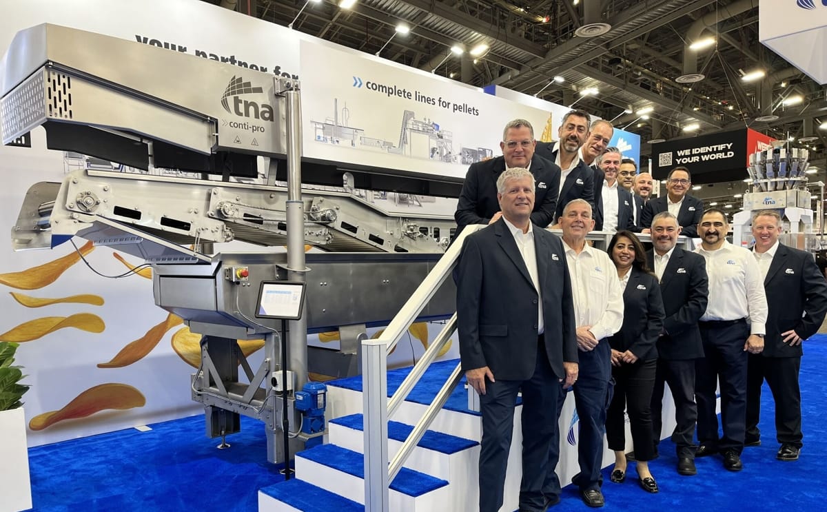 The TNA Solutions team at PACK EXPO Las Vegas 2025, standing alongside the tna conti-pro PEL 3 fryer as they showcased the company’s latest integrated processing and packaging innovations.