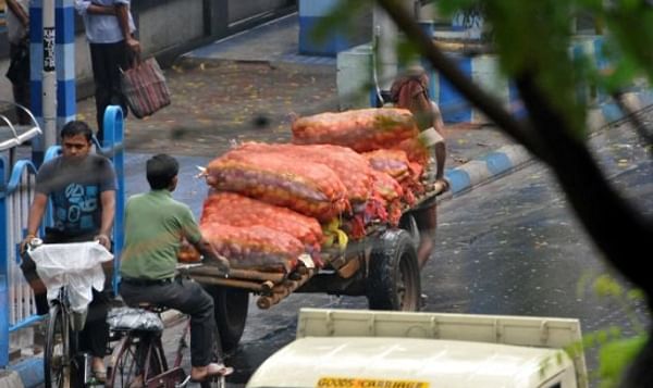 A worker is seen transporting potatoes to a local market after a spell of rain in Kolkata on Wednesday (Courtesy: Ashoke Chakrabarty)