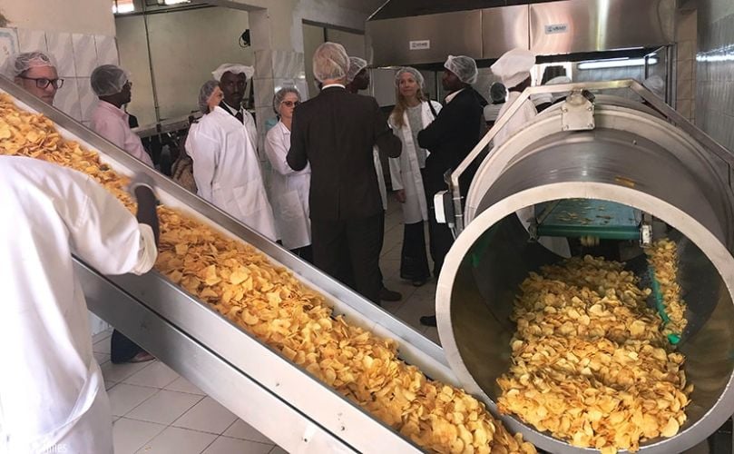 Officials observe the production process at the Hollanda Fair Foods potato processing plant. (Courtesy: Jean d'Amour Mbonyinshuti / New Times)