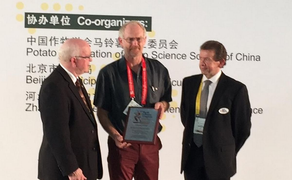 Kevin Clayton Green (center) - one of five Industry Award recipients -  is presented with his award by World Potato Congress Inc. President and CEO, David Thompson (left), and Awards Committee Interim Chair, WPC Vice-President John MacQuarrie (right) duri