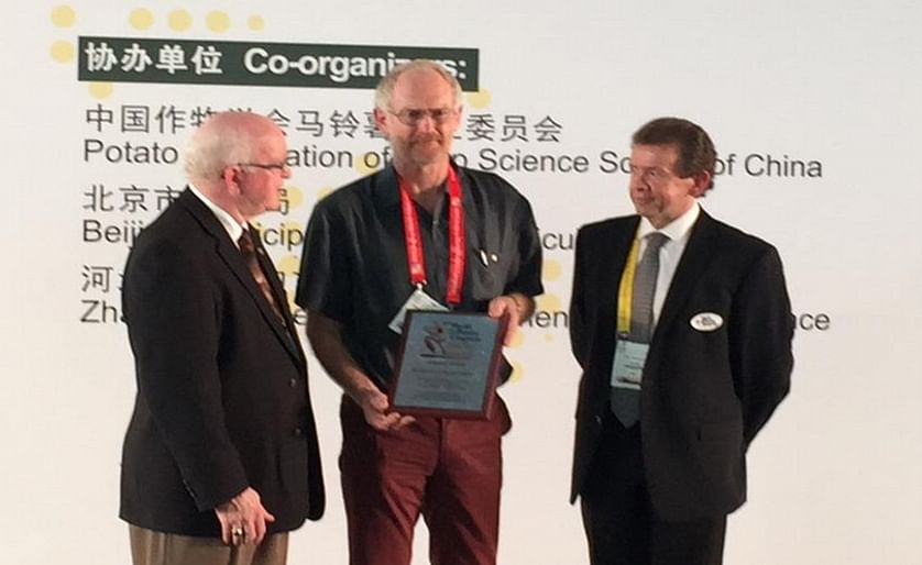 Kevin Clayton Green (center) - one of five Industry Award recipients -  is presented with his award by World Potato Congress Inc. President and CEO, David Thompson (left), and Awards Committee Interim Chair, WPC Vice-President John MacQuarrie (right) duri