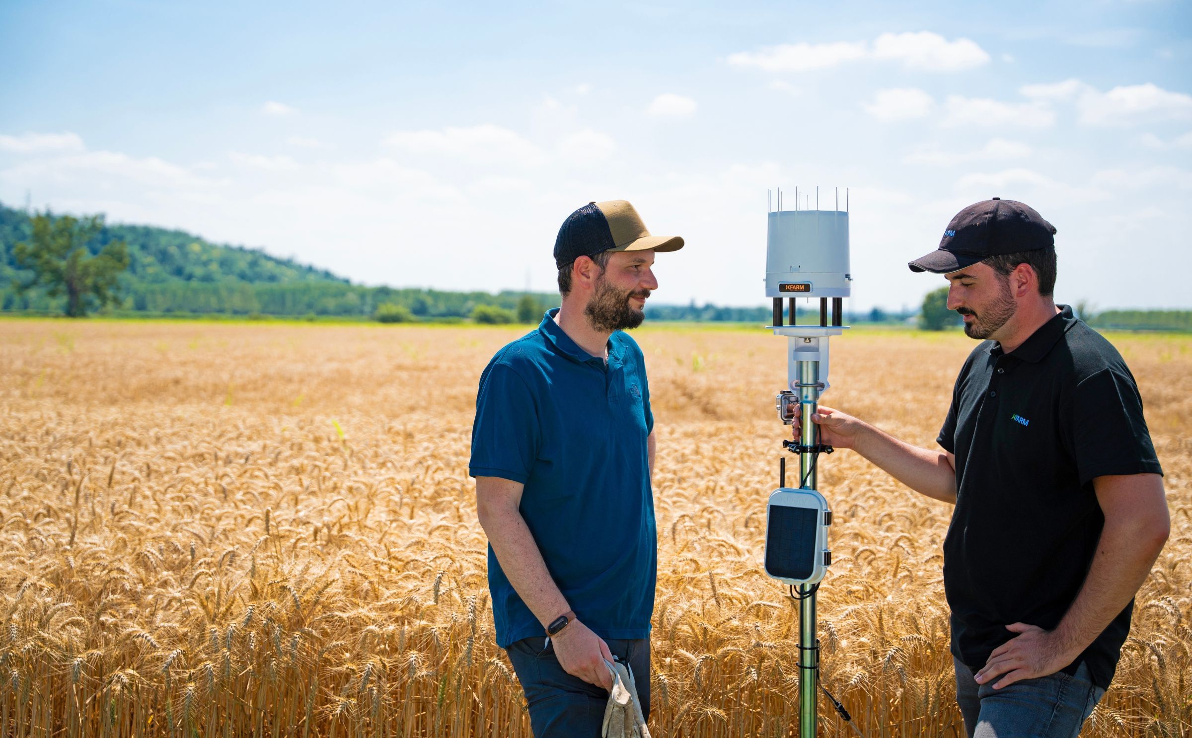Technicians examine an xFarm weather-monitoring station used for real-time climate and crop data collection